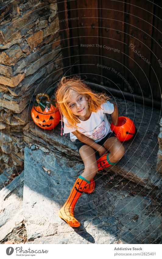 Charmant auf der Veranda sitzend Mädchen Halloween Kürbis Gast Tradition Dekor Design Ferien & Urlaub & Reisen Herbst Festspiele Kind Kindheit Fröhlichkeit