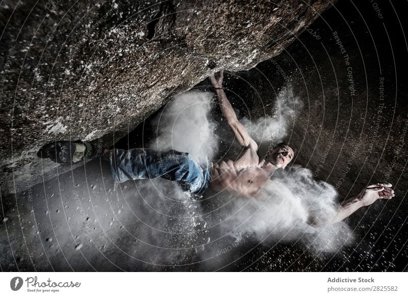 Ein Mann, der aus Magnesium auf den Felsen klettert, Berg in der Dämmerung. Kreativität Mensch Kreide Klettern stark sportlich Entscheidungen Energie Finger