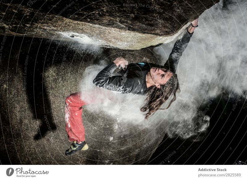 Ein Mann, der aus Magnesium auf den Felsen klettert, Berg in der Dämmerung. Kreativität Mensch Kreide Klettern stark sportlich Entscheidungen Energie Finger