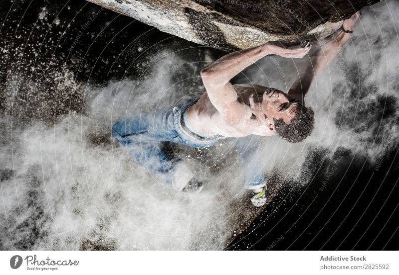 Ein Mann, der aus Magnesium auf den Felsen klettert, Berg in der Dämmerung. Kreativität Mensch Kreide Klettern stark sportlich Entscheidungen Energie Finger