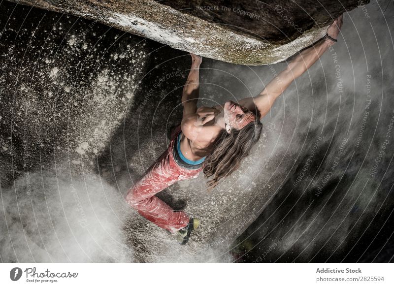 Ein Mann, der aus Magnesium auf den Felsen klettert, Berg in der Dämmerung. Kreativität Mensch Kreide Klettern stark sportlich Entscheidungen Energie Finger