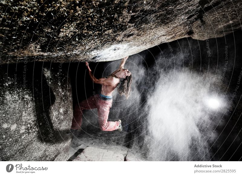 Ein Mann, der aus Magnesium auf den Felsen klettert, Berg in der Dämmerung. Kreativität Mensch Kreide Klettern stark sportlich Entscheidungen Energie Finger