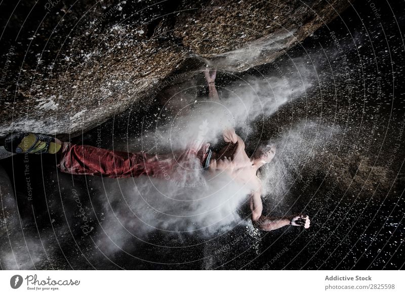 Ein Mann, der aus Magnesium auf den Felsen klettert, Berg in der Dämmerung. Kreativität Mensch Kreide Klettern stark sportlich Entscheidungen Energie Finger