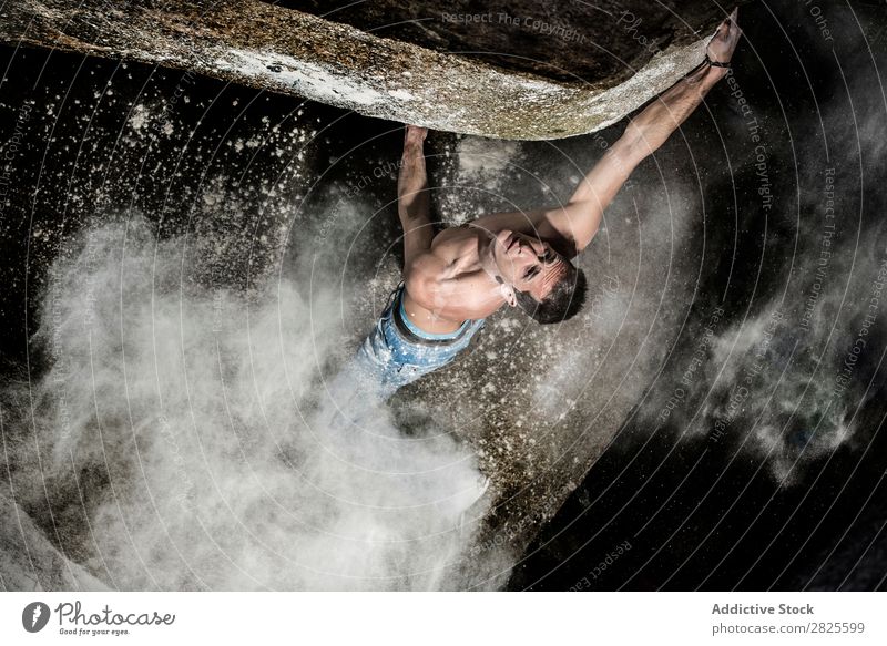 Ein Mann, der aus Magnesium auf den Felsen klettert, Berg in der Dämmerung. Kreativität Mensch Kreide Klettern stark sportlich Entscheidungen Energie Finger