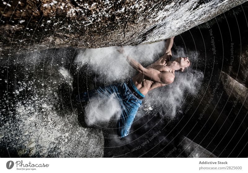 Ein Mann, der aus Magnesium auf den Felsen klettert, Berg in der Dämmerung. Kreativität Mensch Kreide Klettern stark sportlich Entscheidungen Energie Finger