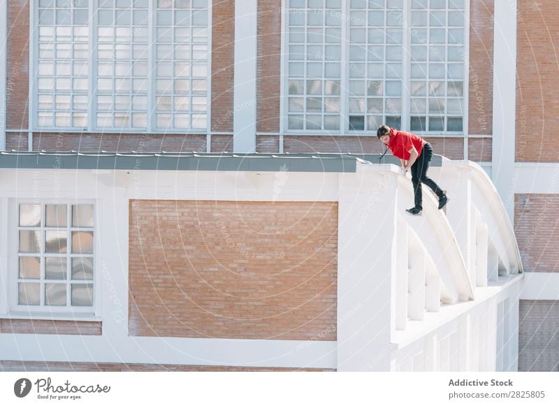 Mann klettert auf das Dach Sportler Le Parkour Tracer Klettern Erholung physisch Risiko Dachterrasse Motivation Aktion Läufer Stadt Stunt extrem Adrenalin