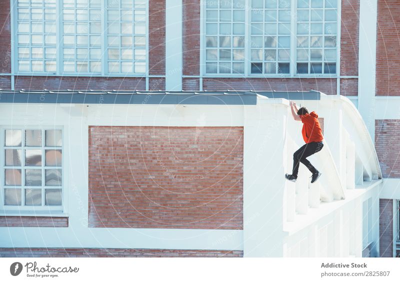 Mann klettert auf das Dach Sportler Le Parkour Tracer Klettern Erholung physisch Risiko Dachterrasse Motivation Aktion Läufer Stadt Stunt extrem Adrenalin