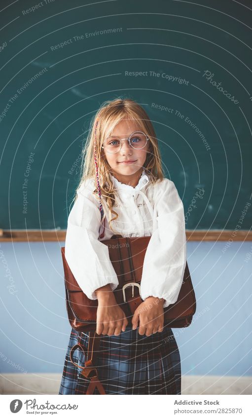 Schüler an der Tafel mit Aktentasche in der Hand Mädchen Klassenraum stehen heiter Glück Buch Kreide niedlich Bildung Schule Schulklasse Jugendliche lernen Kind