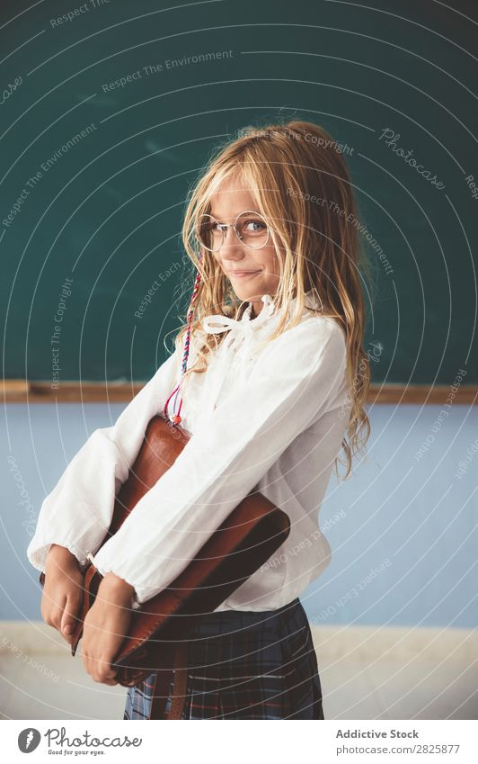 Schüler an der Tafel mit Aktentasche in der Hand Mädchen Klassenraum stehen heiter Glück Buch Kreide niedlich Bildung Schule Schulklasse Jugendliche lernen Kind