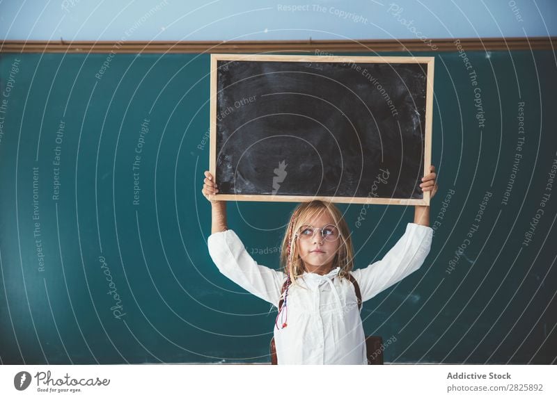 Glückliches Mädchen stehend mit Tafel Klassenraum Halt schreien über Kopf heiter niedlich Bildung Schule Schulklasse Schüler Jugendliche lernen Kind