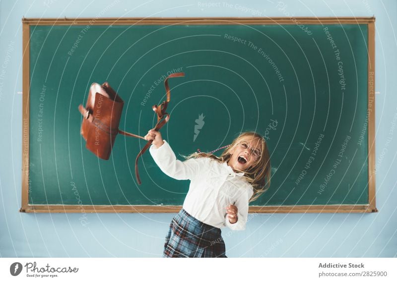 Mädchen wirft Rucksack im Klassenzimmer. Klassenraum Tafel Freude Werfen Ferien & Urlaub & Reisen Glück heiter stehen niedlich Bildung Schule Schulklasse