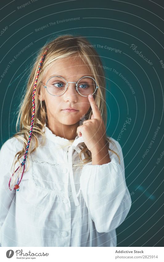 Niedliche Schülerin, die in einem Klassenzimmer posiert. Mädchen Klassenraum Tafel Brillenträger heiter stehen niedlich Bildung Schule Schulklasse Jugendliche