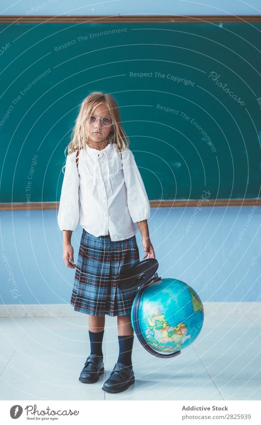 Schülermädchen posiert mit Globus Mädchen Klassenraum Geografie niedlich Bildung Schule Schulklasse Jugendliche lernen Kind Schulunterricht Pupille Wissen