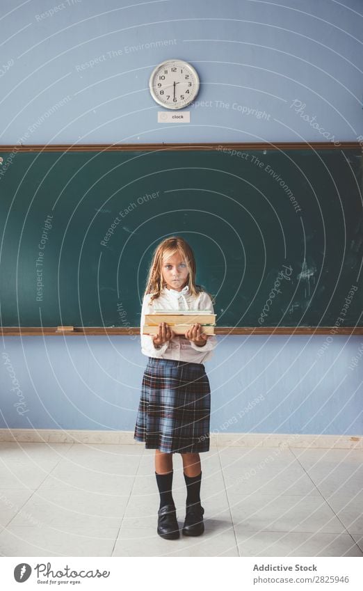 Schüler an der Tafel mit Büchern in der Hand Mädchen Klassenraum stehen heiter Glück Buch Kreide niedlich Bildung Schule Schulklasse Jugendliche lernen Kind