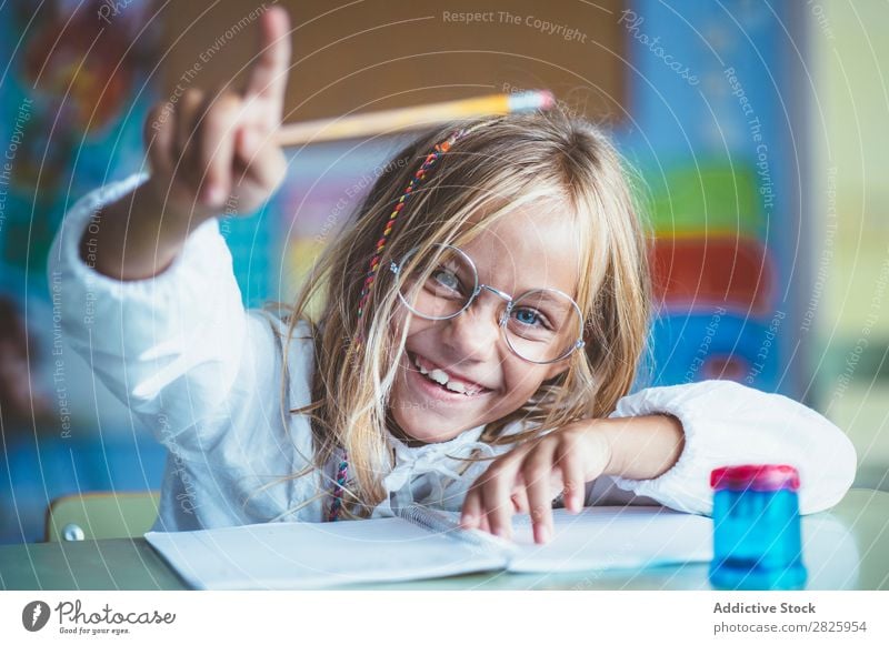 Nachdenkliches Mädchen beim Schreiben im Unterricht Klassenraum sitzen Schreibtisch schreibend Bleistift Zeichnung Denken Fürsorge gelangweilt niedlich Bildung