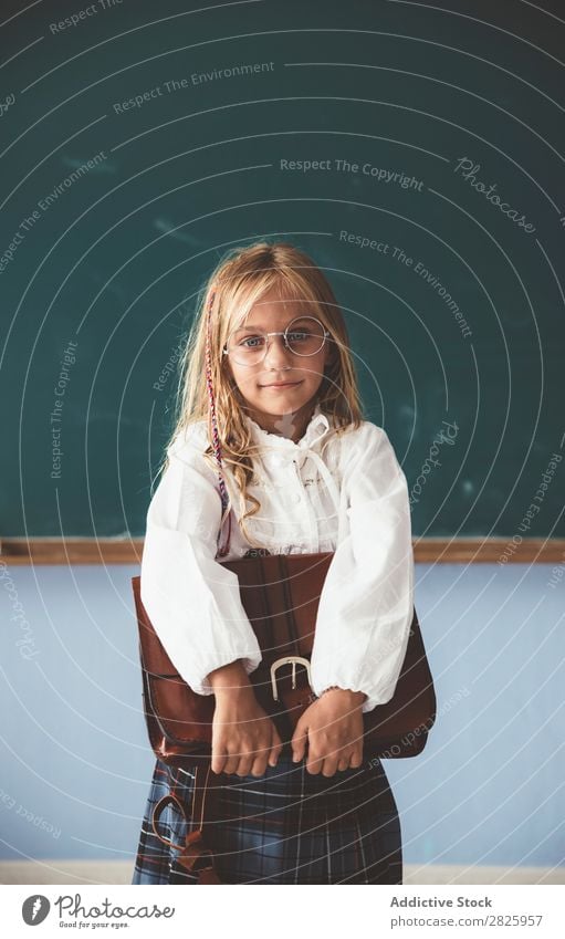 Schüler an der Tafel mit Aktentasche in der Hand Mädchen Klassenraum stehen heiter Glück Buch Kreide niedlich Bildung Schule Schulklasse Jugendliche lernen Kind