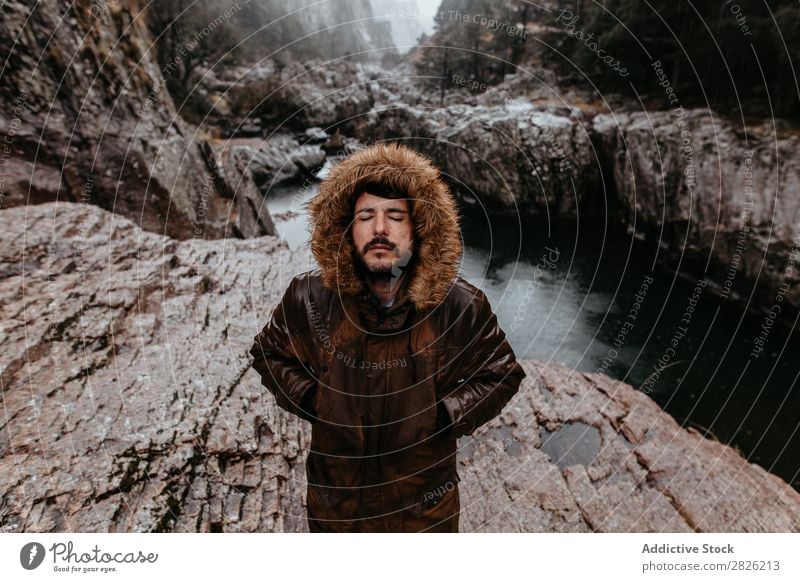 Mann in Jacke am Fluss stehend Berge u. Gebirge Natur Augen geschlossen Hände in den Taschen Landschaft Wasser Außenaufnahme schön Umwelt Baum Mensch ökologisch