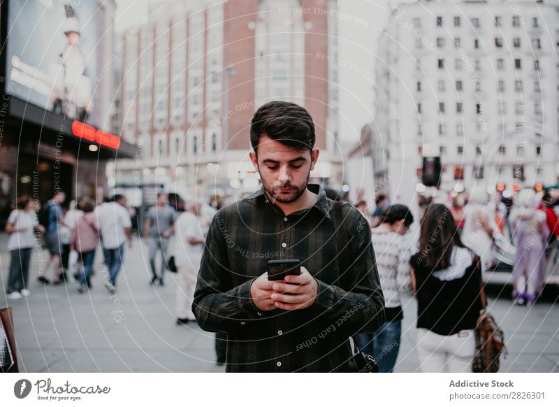 Mann mit Smartphone auf der Straße PDA lässig stehen Browsen benutzend Surfen Großstadt Telefon Mobile Lifestyle Stadt Jugendliche Fürsorge Denken besinnlich