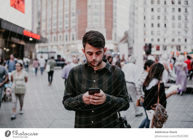 Mann mit Smartphone auf der Straße PDA lässig stehen Browsen benutzend Surfen Großstadt Telefon Mobile Lifestyle Stadt Jugendliche Fürsorge Denken besinnlich