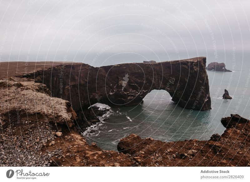 Isländisches Naturwunder Mann Felsen Meer Island Hand Höhe ausgestreckt Landschaft Aussicht Küste trist extrem Seeküste Abenteuer Berge u. Gebirge Wildnis