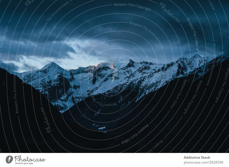 Verschneite Berge unter starkem Himmel Natur Winter Berge u. Gebirge Wolken schwer Landschaft Schnee Ferien & Urlaub & Reisen Eis schön weiß Jahreszeiten kalt