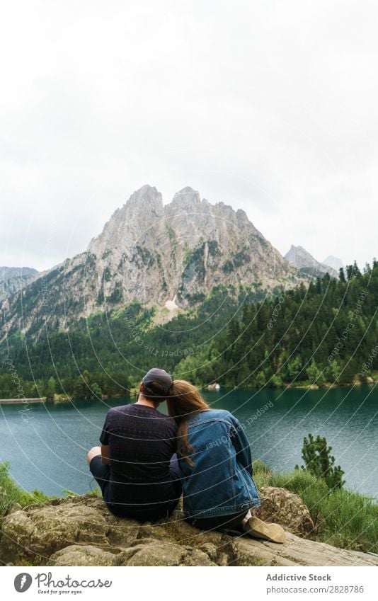 Freunde, die am See in den Bergen sitzen. Frau Mann Berge u. Gebirge Zusammensein Freude wandern Wasser umarmend Glück Ferien & Urlaub & Reisen Abenteuer