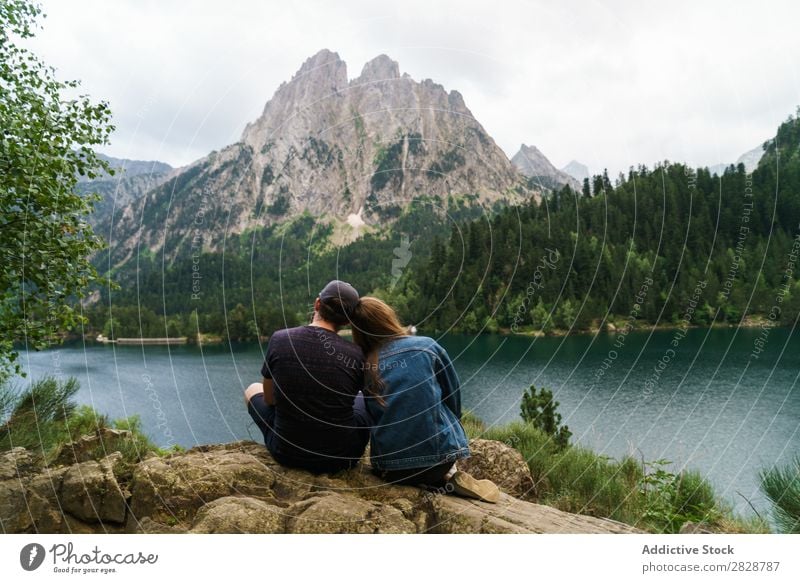 Freunde, die am See in den Bergen sitzen. Frau Mann Berge u. Gebirge Zusammensein Freude wandern Wasser umarmend Glück Ferien & Urlaub & Reisen Abenteuer