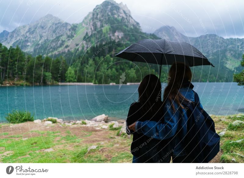 Frauen unter Schirm in den Bergen Berge u. Gebirge Zusammensein stehen wandern See Wasser Regenschirm heiter Glück Ferien & Urlaub & Reisen Abenteuer Tourist