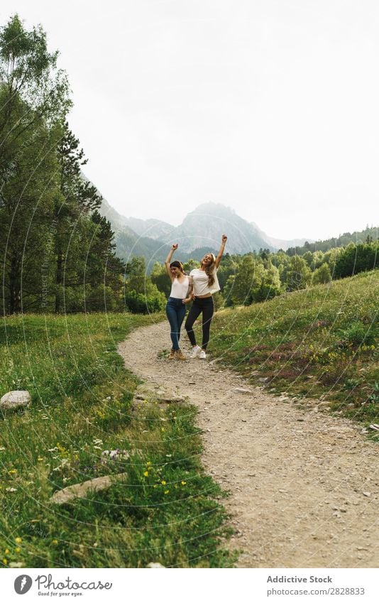 Fröhliche Frauen, die auf der Bergstraße posieren. laufen Straße ländlich Freundschaft Rucksack Natur Mädchen Jugendliche schön Ferien & Urlaub & Reisen