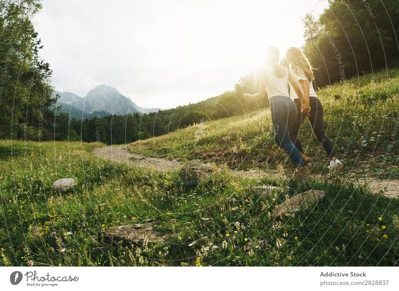 Fröhliche Frauen, die auf der Bergstraße laufen. Straße ländlich Freundschaft Rucksack Natur Mädchen Jugendliche schön Ferien & Urlaub & Reisen Tourismus