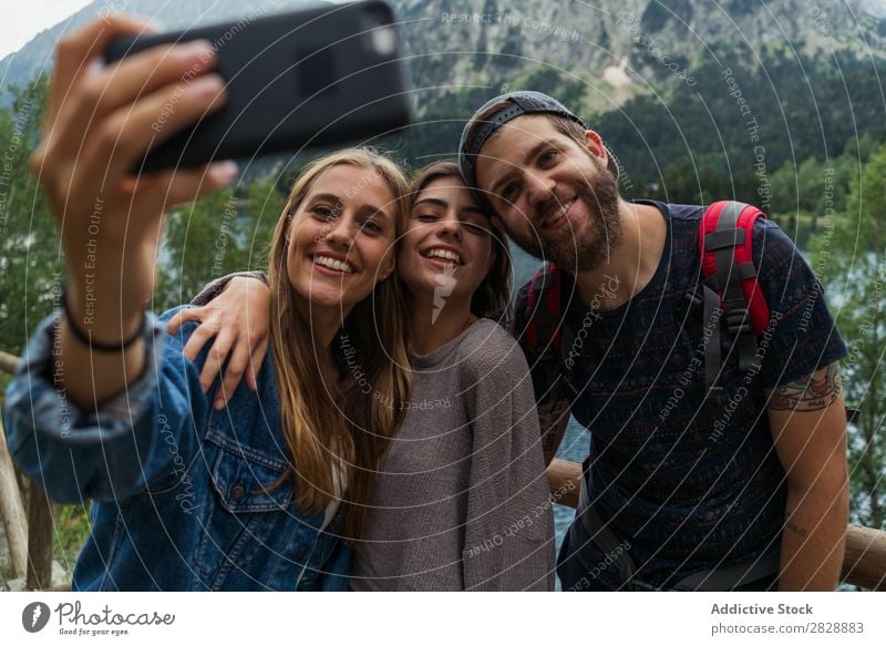 Freunde, die in den Bergen Selfie machen. Frau Mann Berge u. Gebirge laufen PDA nehmen Zusammensein Lächeln wandern See Wasser umarmend heiter Glück