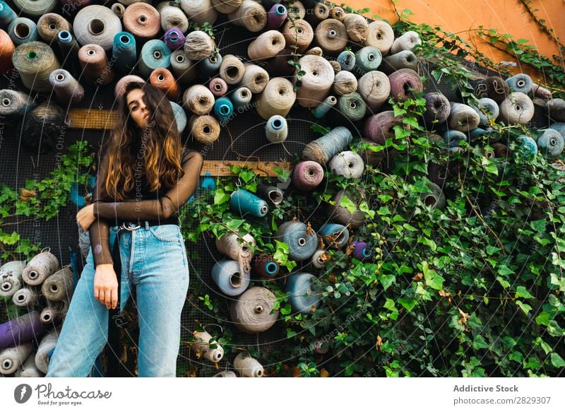 Frau an der Wand mit Rollen Stil Straße Pflanze Walze Sträucher Stadt Körperhaltung Porträt attraktiv Beautyfotografie trendy Lifestyle hübsch Mode Jugendliche