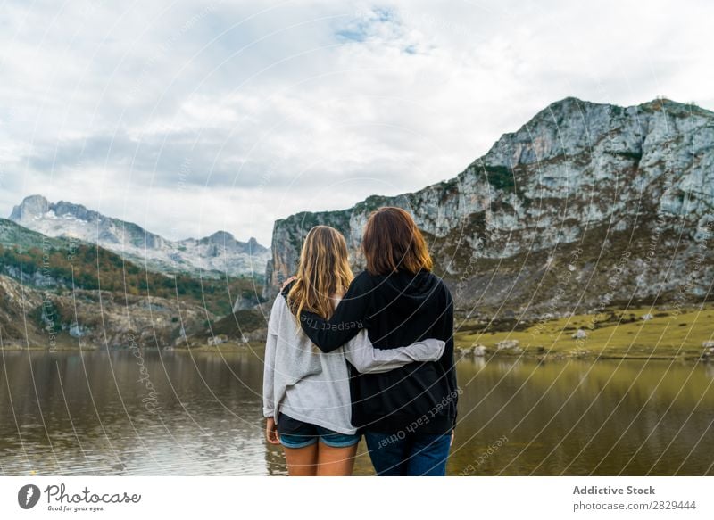 Frauen am See stehend Wiese umarmend Zusammensein Freundschaft Erholung Berge u. Gebirge Natur Feld Mädchen Gras schön Jugendliche grün Frühling Mensch