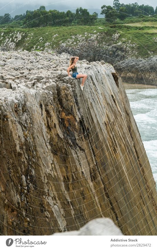 Frau sitzt auf einem Felsvorsprung. Klippe sitzen schön Felsen Sommer Natur Ferien & Urlaub & Reisen Wasser Landschaft Jugendliche blau Lifestyle Meer Freiheit