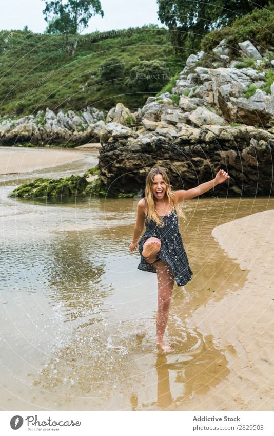 Fröhliches Mädchen, das im Wasser spielt. Frau Strand Spaß haben Geplätscher Natur Fröhlichkeit heiter Ferien & Urlaub & Reisen Sommer Felsen tropisch Spielen