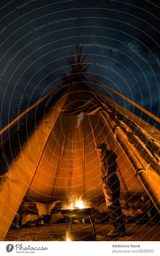 Mann wärmt sich im Zelt auf Winter Natur kalt Norden bedeckt Licht Nacht Freudenfeuer Mensch Erwärmung stehen Tourist Reisender Wald Schnee Jahreszeiten weiß