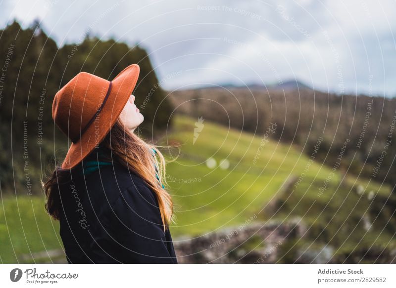 Frau sitzt auf einem Zaun auf dem Feld. sitzen grün Natur Wiese Erholung ruhen Wegsehen Hut Frühling Sommer Gras Landschaft Landwirtschaft ländlich Sonnenlicht