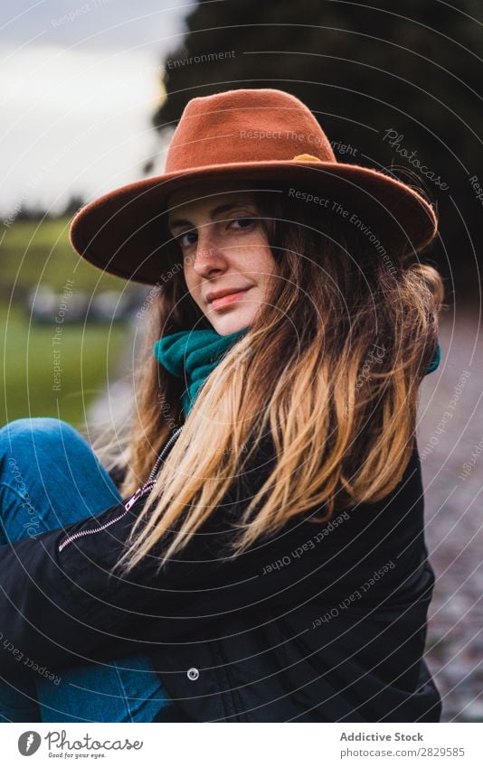 Frau sitzt auf einem Zaun auf dem Feld. sitzen grün Natur Wiese Erholung ruhen Hut Frühling Sommer Gras Landschaft Landwirtschaft ländlich Sonnenlicht Bauernhof