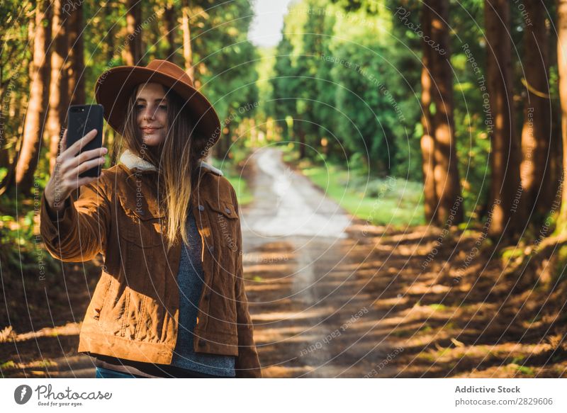 Lächelnde Frau nimmt Selfie im Wald. Tourist grün Natur Umwelt heiter Glück PDA nehmen Schuss Hut hübsch natürlich Jahreszeiten Pflanze Blatt Licht frisch hell