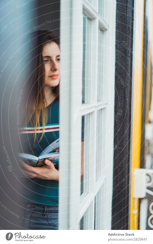 Träumendes Mädchen, das durchs Fenster wegblickt. Frau träumen Beautyfotografie Porträt schön besinnlich genießen Reflexion & Spiegelung Denken Erholung