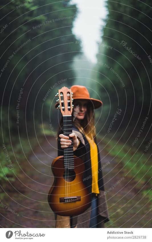 Frau zeigt Ukulele im Wald Fröhlichkeit Freiheit Nebel Reisender Ausdruck Aufregung Bewegung romantisch Energie Ausflug kalt über der Erde Erholung Lifestyle