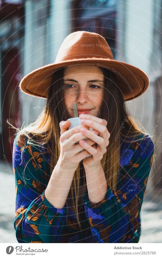 Lächelnde Frau mit Tasse im Außencafé hübsch Stil Straße Hut Kaffee Café Außenaufnahme Mode schön Jugendliche Porträt attraktiv Großstadt Lifestyle Model