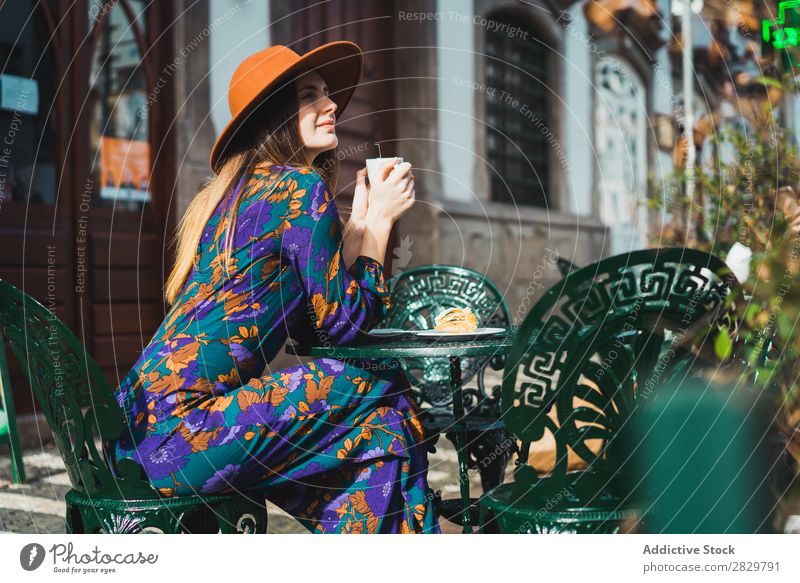 Lächelnde Frau mit Tasse im Außencafé hübsch Stil Straße Hut Kaffee Café Außenaufnahme Mode schön Jugendliche Porträt attraktiv Großstadt Lifestyle Model