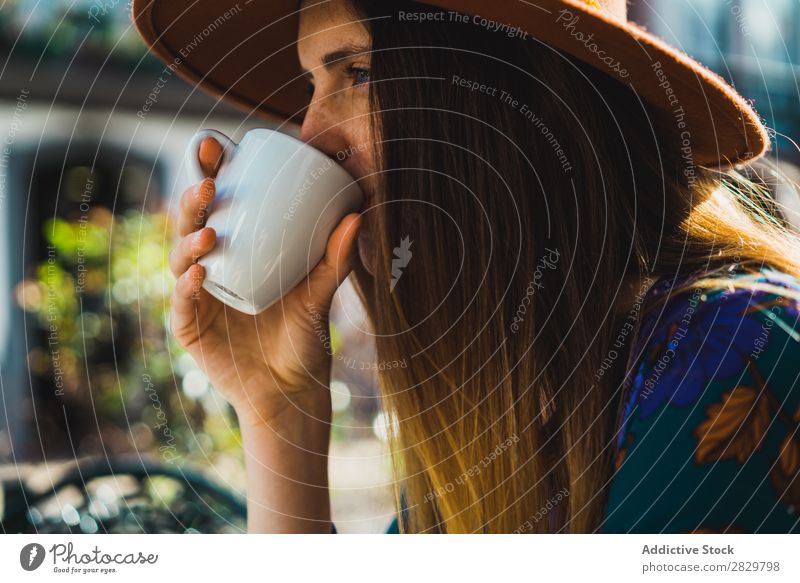 Lächelnde Frau mit Tasse im Außencafé hübsch Stil Straße Hut Kaffee Café Außenaufnahme Mode schön Jugendliche Porträt attraktiv Großstadt Lifestyle Model