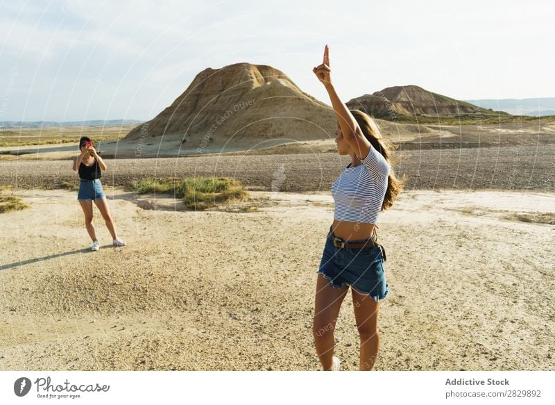 Frau macht Fotos von einer Freundin. Körperhaltung Natur hübsch Hände hoch Lächeln heiter Glück Jugendliche schön natürlich Beautyfotografie Porträt attraktiv