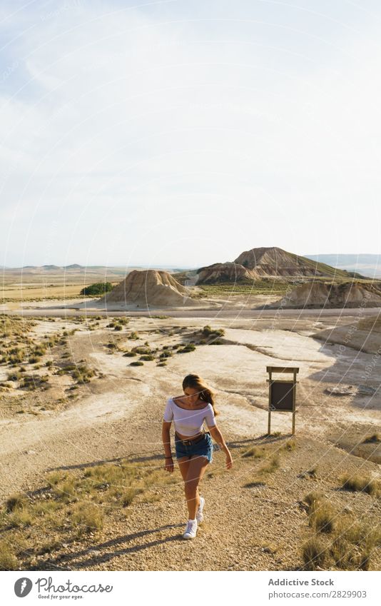 Frau, die auf einem sandigen Hügel spazieren geht. laufen Ferien & Urlaub & Reisen Natur Lifestyle Abenteuer wandern Felsen Sand Zeichen Aussicht schön