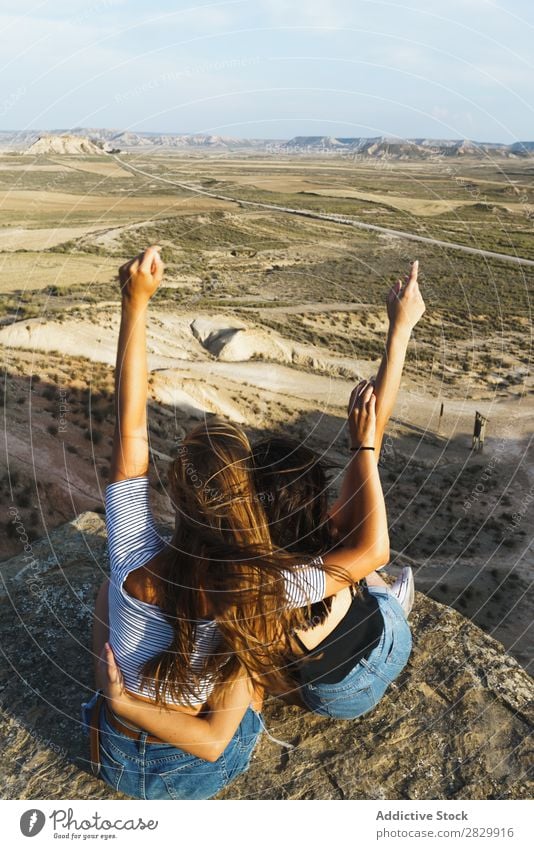 Aufgeregte Frauen, die auf einer Klippe liegen. Erholung Ferien & Urlaub & Reisen Abenteuer Felsen Berge u. Gebirge Tourist Freundschaft Zusammensein Lächeln