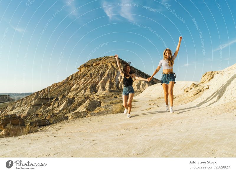 Glückliche Frauen, die auf dem Hügel spazieren gehen. Klippe Aufregung rennen Händchenhalten Freiheit Ferien & Urlaub & Reisen Erfolg Top Berge u. Gebirge