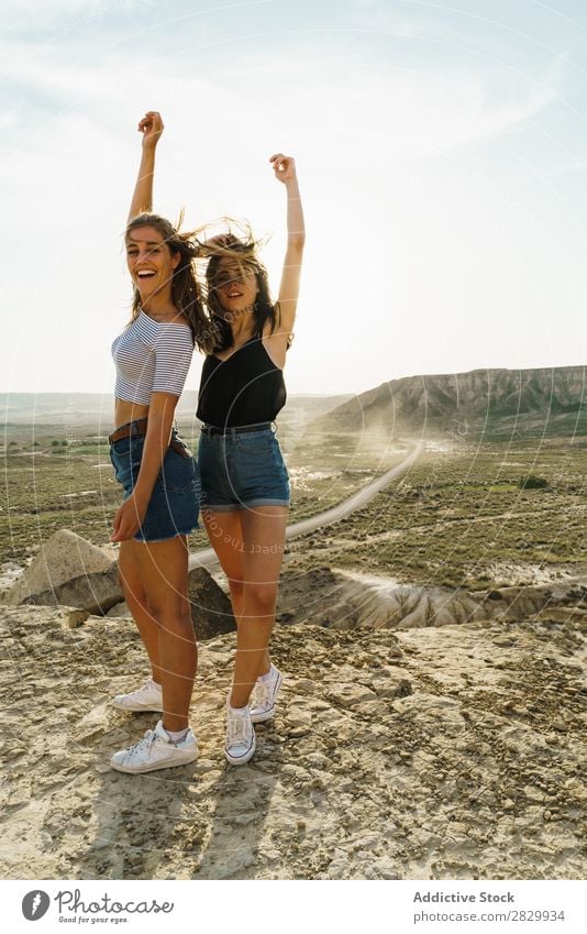 Fröhliche Frauen, die auf einer Klippe stehen. Aufregung Blick in die Kamera Lächeln heiter Umarmen Freiheit Ferien & Urlaub & Reisen Erfolg Top