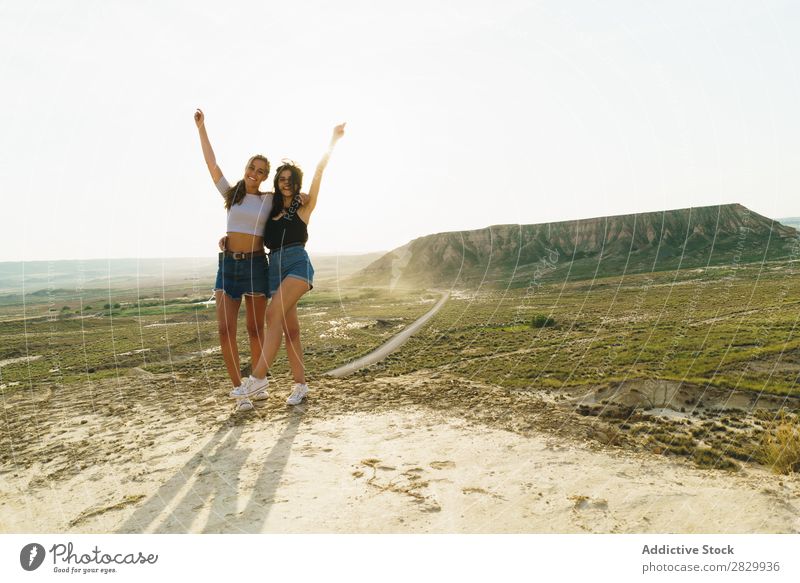 Fröhliche Frauen, die auf einer Klippe stehen. Aufregung umarmend Blick in die Kamera Lächeln heiter Umarmen Freiheit Ferien & Urlaub & Reisen Erfolg Top